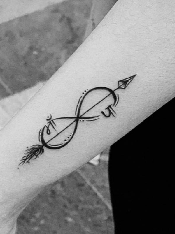 A tattoo of an arrow with feathers at the end going through the infinity sign 