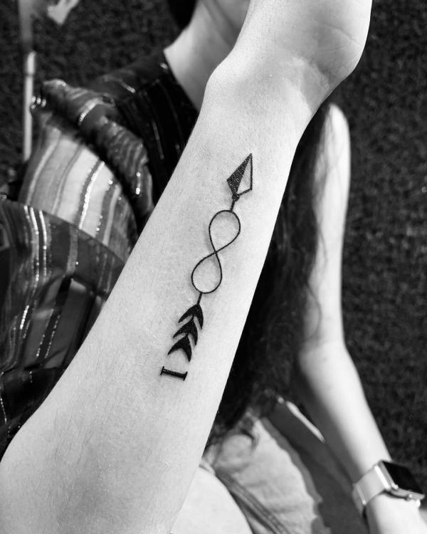 Forearm tattoo with arrow through infinity
