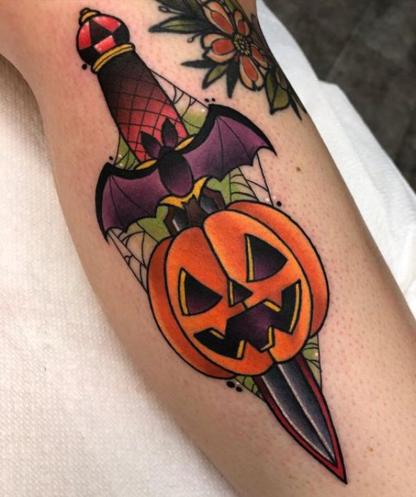 A dagger pierced a pumpkin tattoo in new traditional style