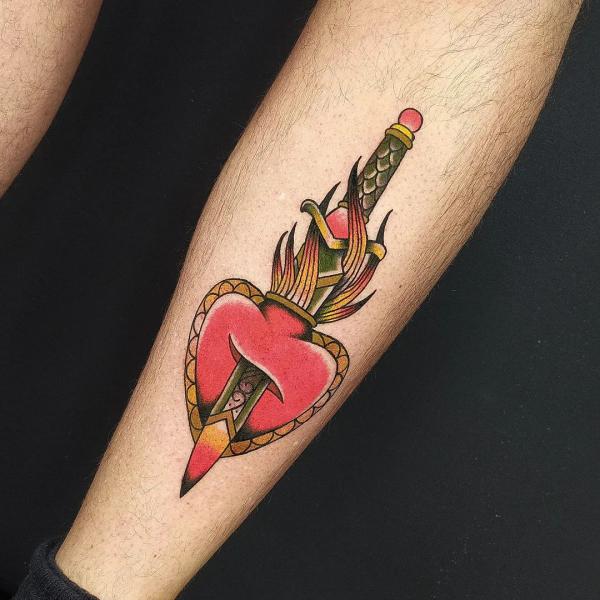 A dagger through a sacred heart tattoo in new school style
