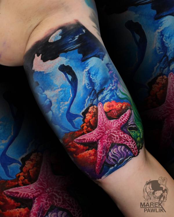 A diving mermaid and starfish in undersea bicep tattoo