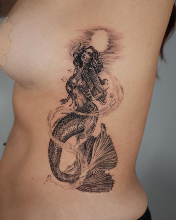 A mermaid in water with bubbles and sun