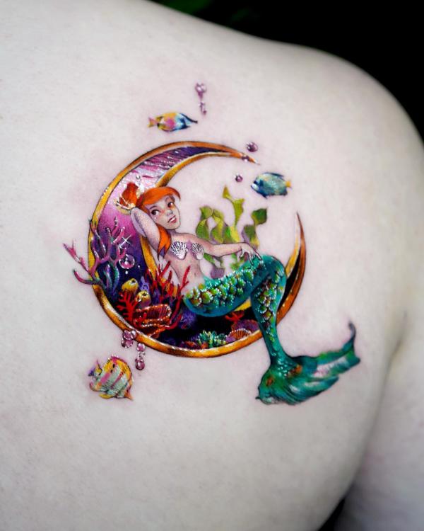 A mermaid lying on crescent moon tattoo