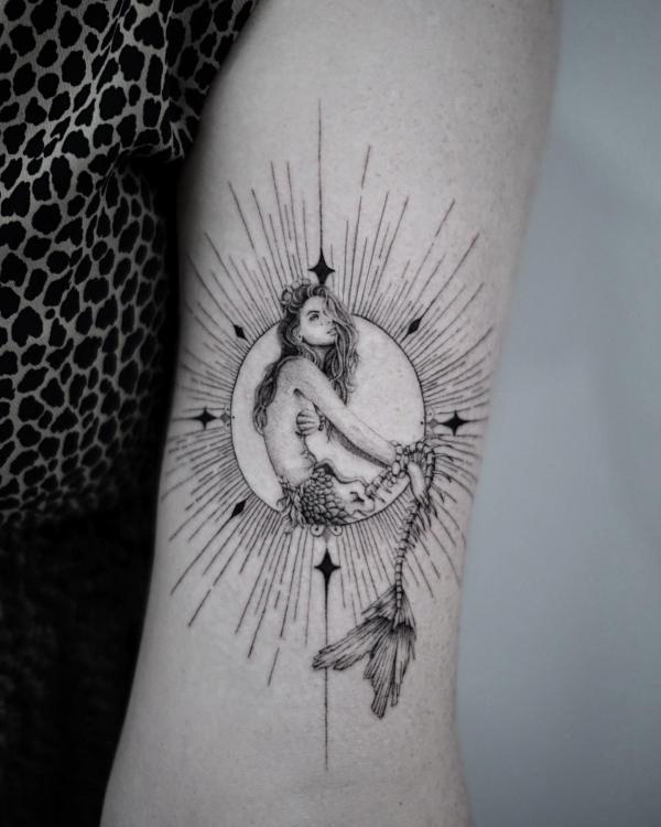 A mermaid sitting in sun with halo