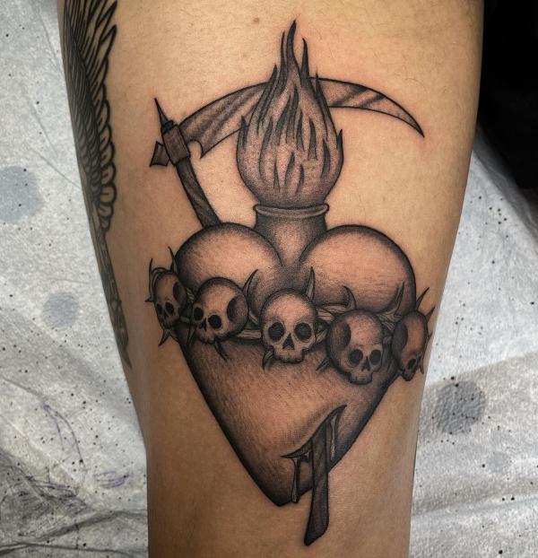 Black and gray sacred heart tattoo with skulls