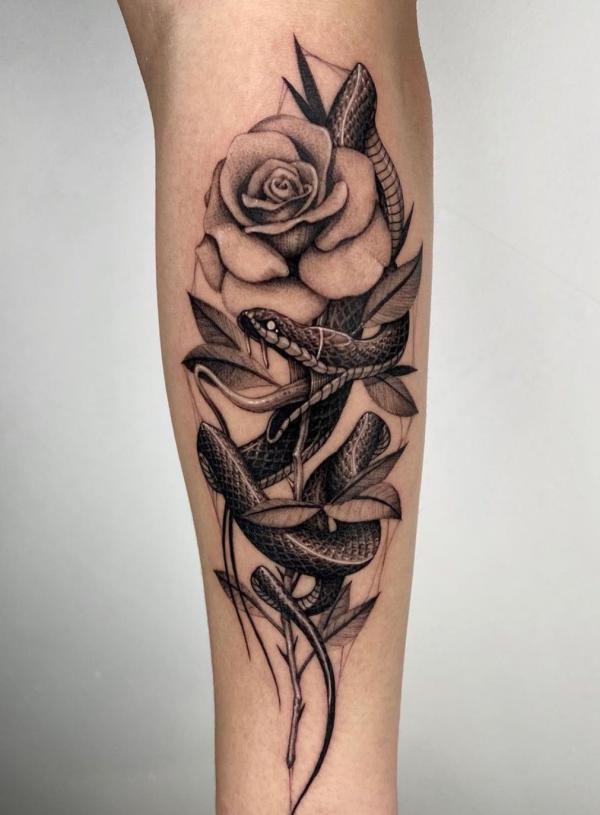 Black and grey snake and rose forearm tattoo