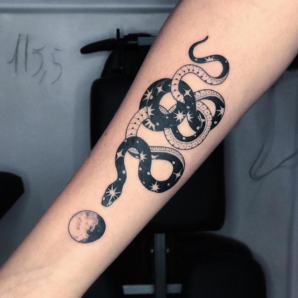 Black and white snake with moon and stars tattoo on forearm