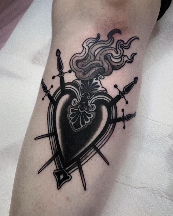 Black sacred heart tattoo with daggers