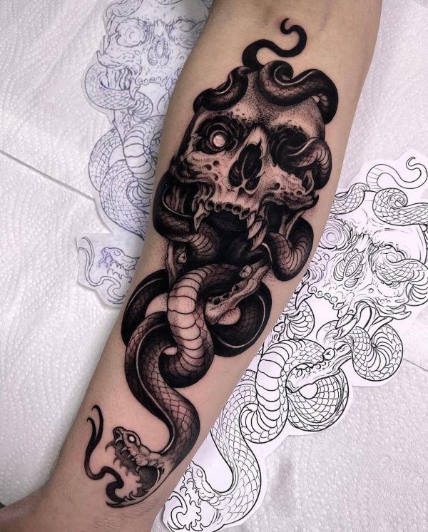 Blackwork snake and skull forearm tattoo