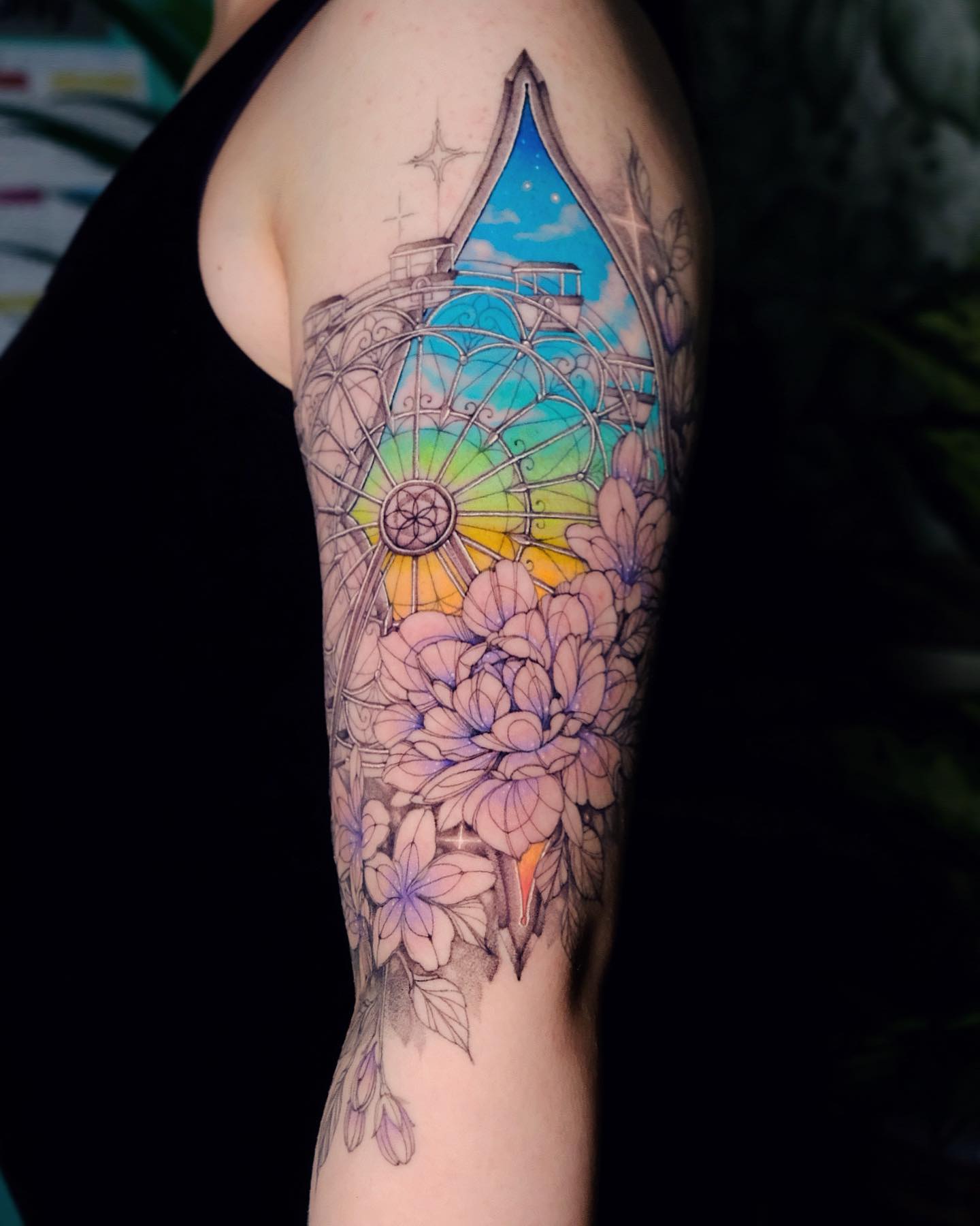 Ferris wheel anf flowers upper arm tattoo