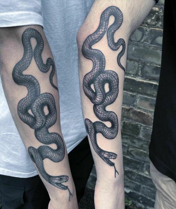 Matching snake forearm tattoos