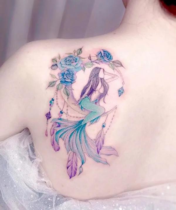Mermaid on crescent moon with blue rose tattoo