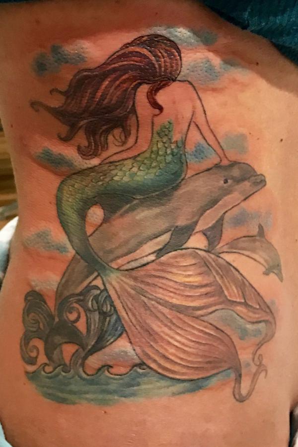 Mermaid sitting on a dolphin side tattoo