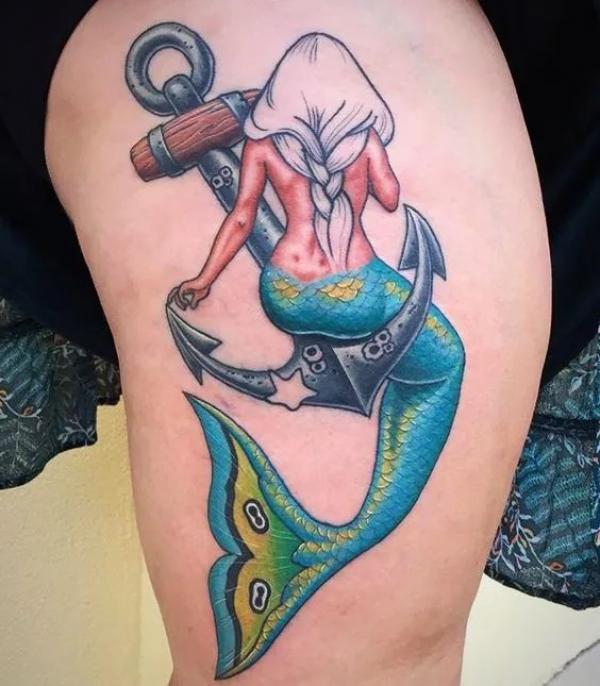 Mermaid sitting on an anchor tattoo