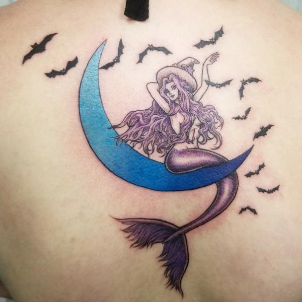 Modern mermaid sitting on crescent moon with flying bats tattoo