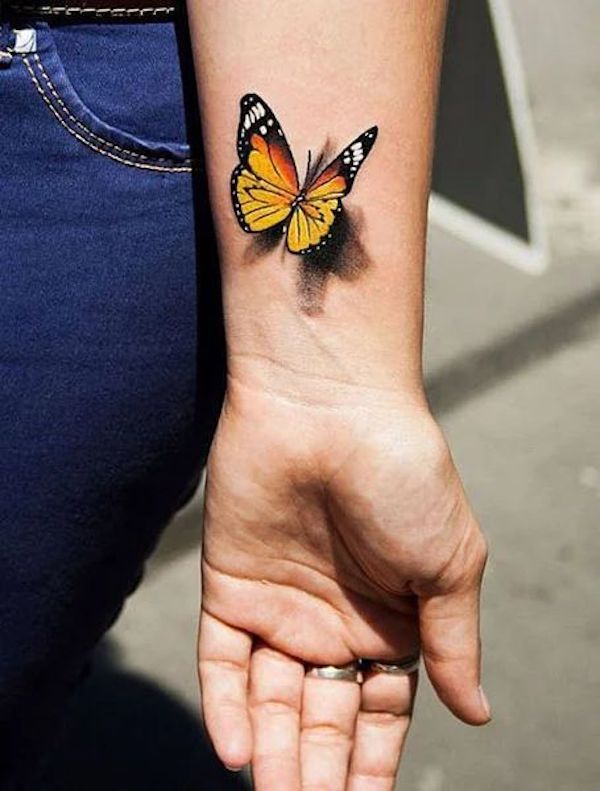 Yellow butterfly tattoo on the right upper arm