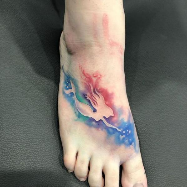 Negative space mermaid foot tattoo on watercolor backdrop