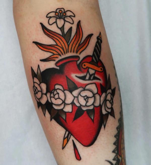 Old school sacred heart tattoo with a dagger and roses