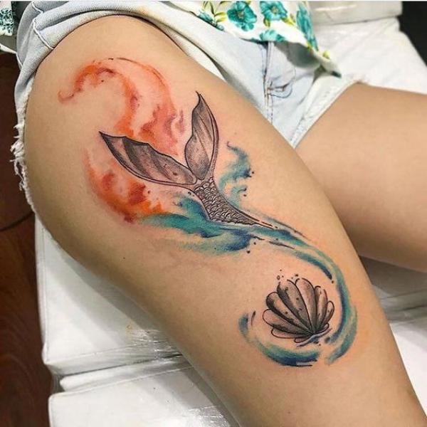Shell and the tail of mermaid on watercolor thigh tattoo