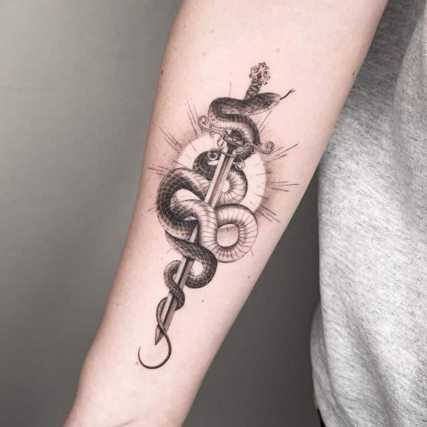 Snake entwined with dagger forearm tattoo