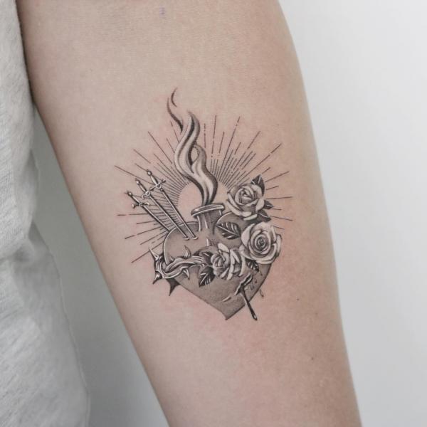 The silver sacred heart tattoo with daggers roses and halo
