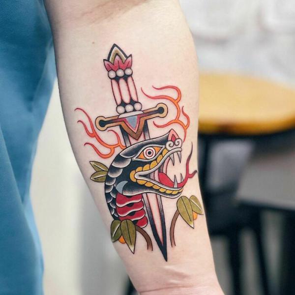 Traditional snake and dagger tattoo forearm