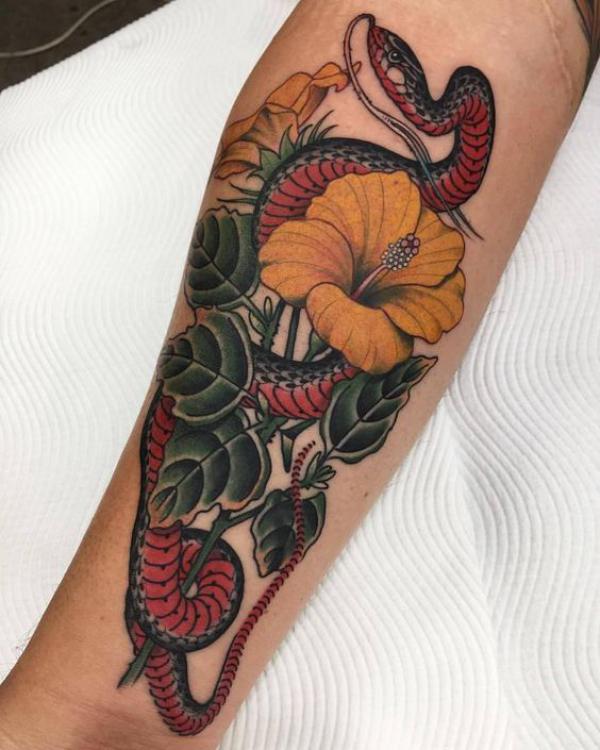 Traditional snake and hibiscus tattoo forearm