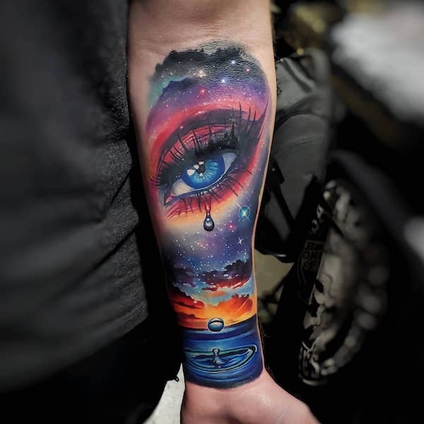 Watercolor teardrop eye galaxy forearm tattoo