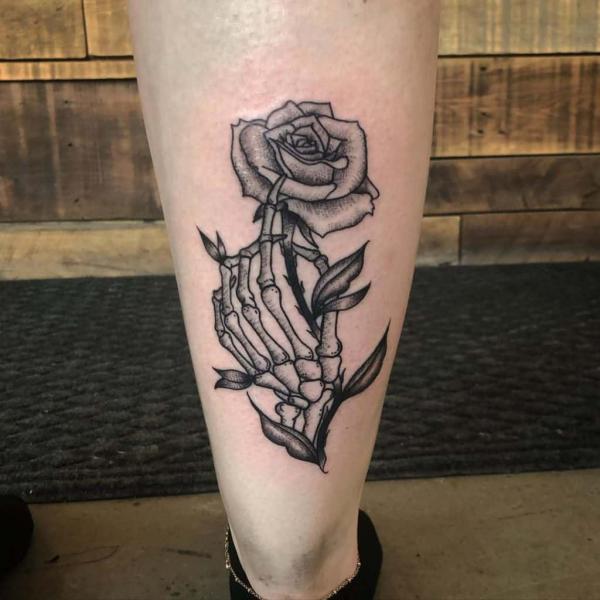 A blooming rose with a skeletal hand