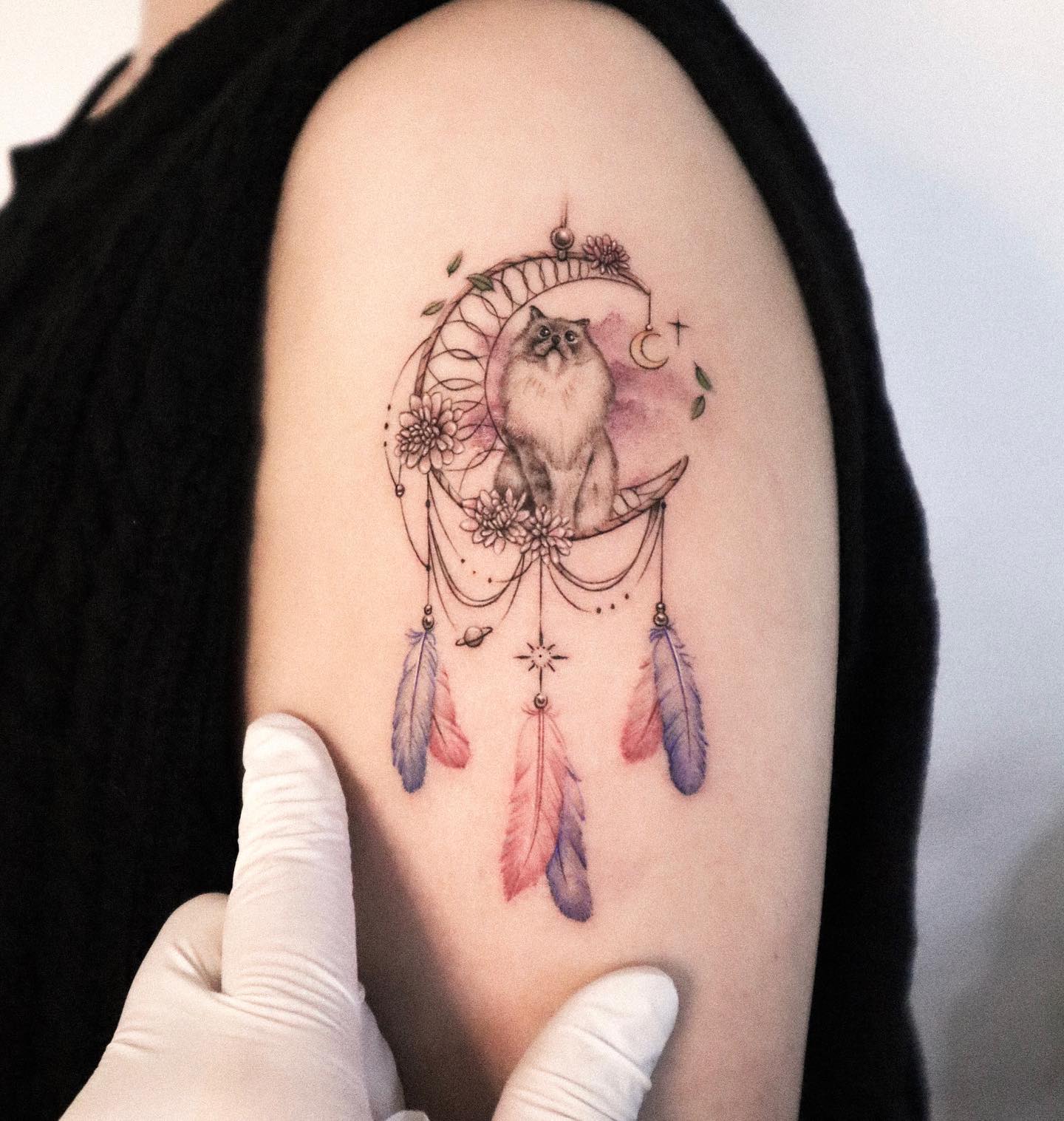 A cute cat sitting on a crescent moon with feather pendant