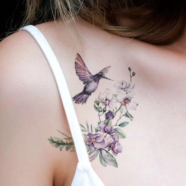A honeybird is flying near violet flower