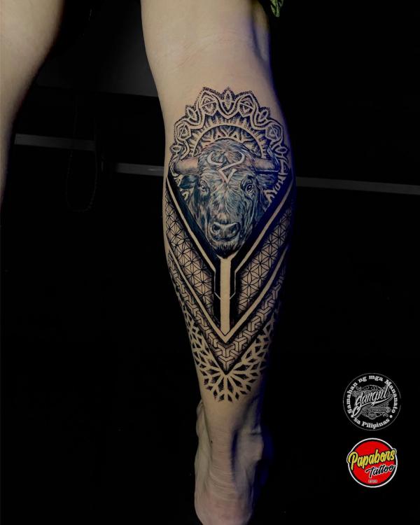 A realistic bull head surrounded with mandala and sacred geometric patterns