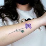 A stem of violet flower on forearm