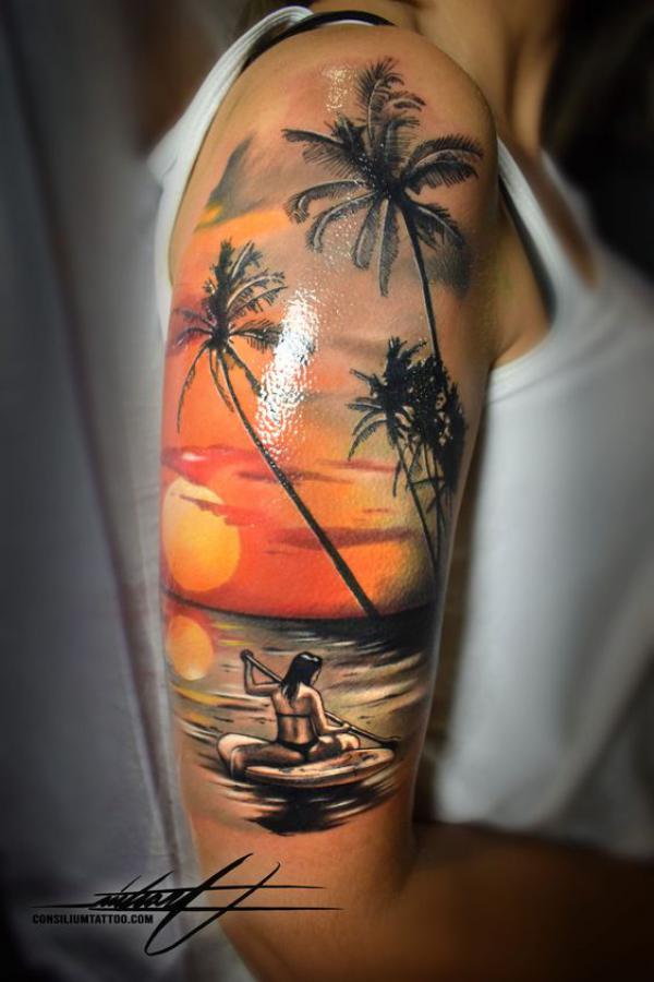 A woman rowing in the sea under palm trees at sunset