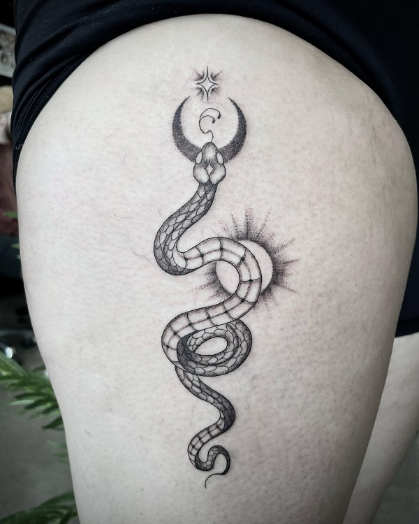 Black and white snake tattoo with sun moon and stars
