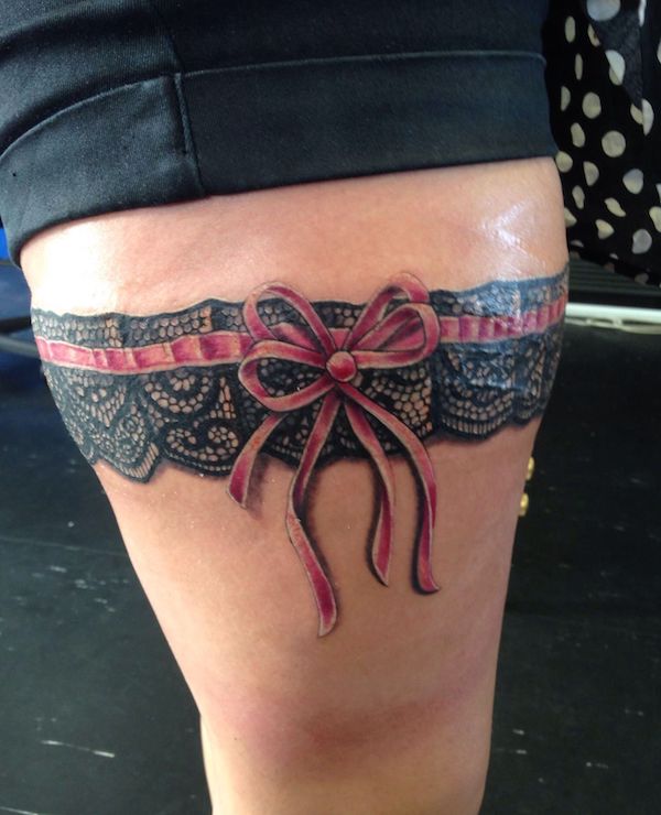 Black lace garter encircled with red ribbon with bow
