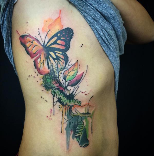 Butterfly metamorphosis tattoo on rib in watercolor style