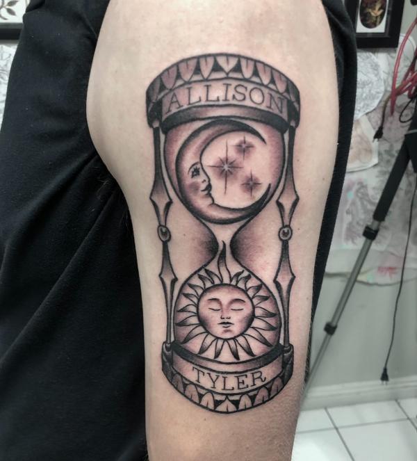 Hourglass with sun on one side and moon and stars another side