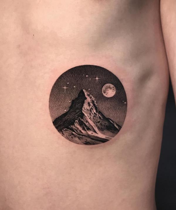 Minimalist mountain tattoo with moon and stars