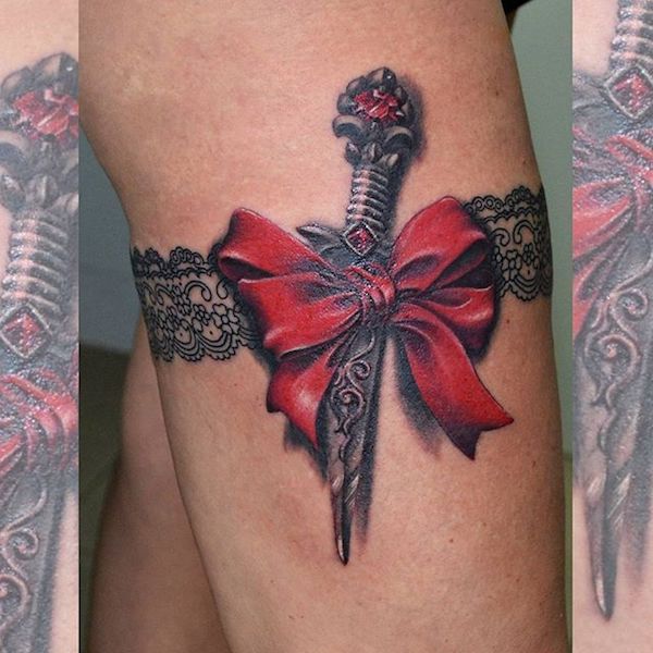 Realistic red bow and dagger garter tattoo