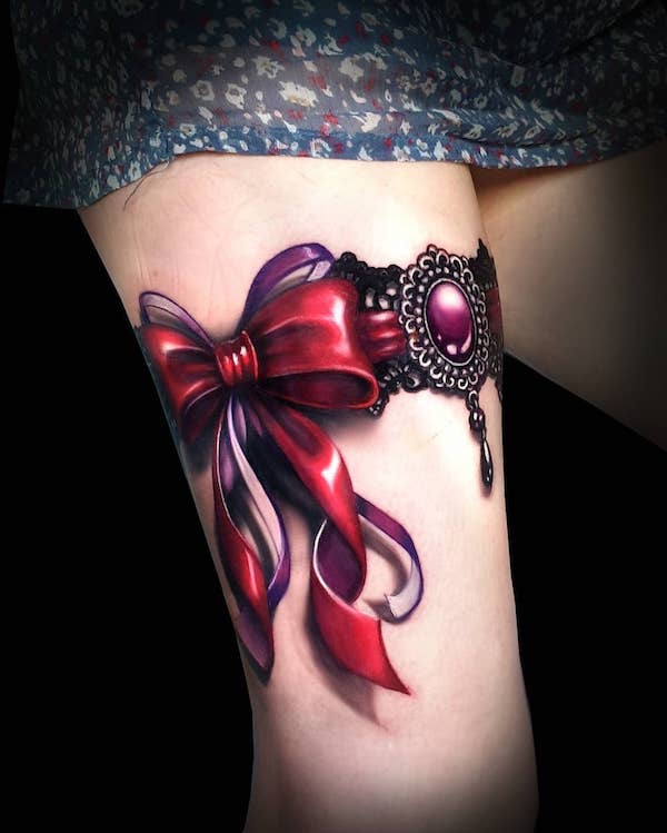Realistic red bow with jewelry garter tattoo