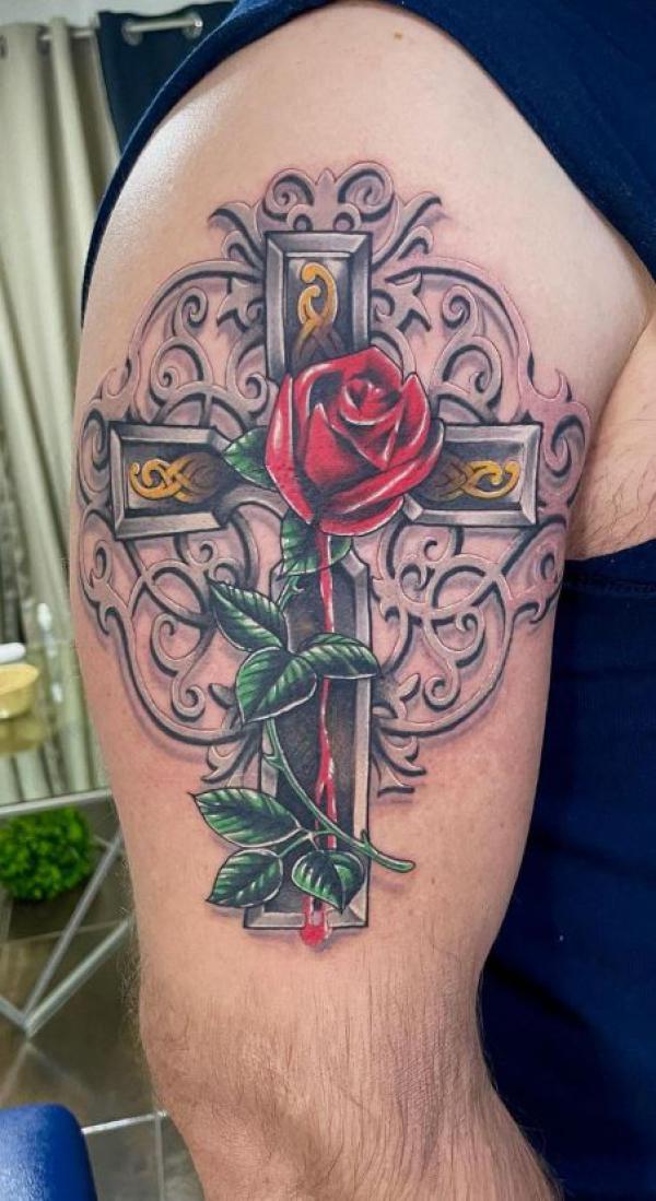 Microrealistic flower cross tattoo on the inner arm