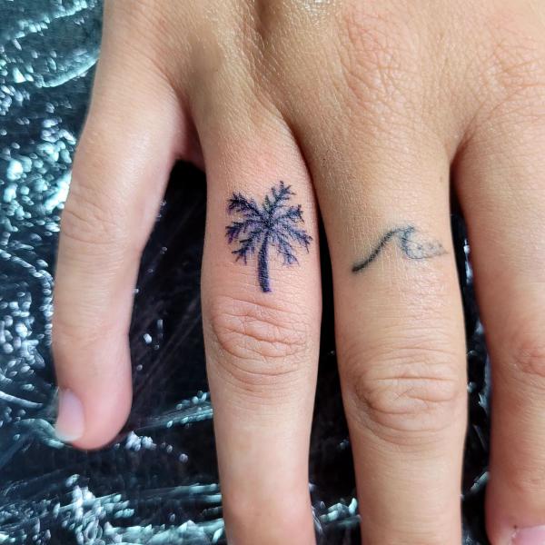 Tiny palm tree and wave finger tattoo