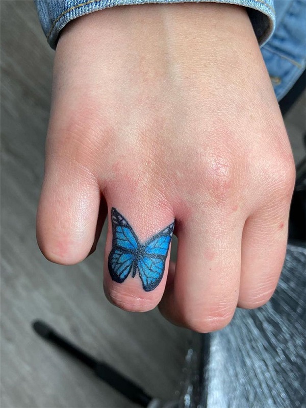 Blue butterfly finger tattoo