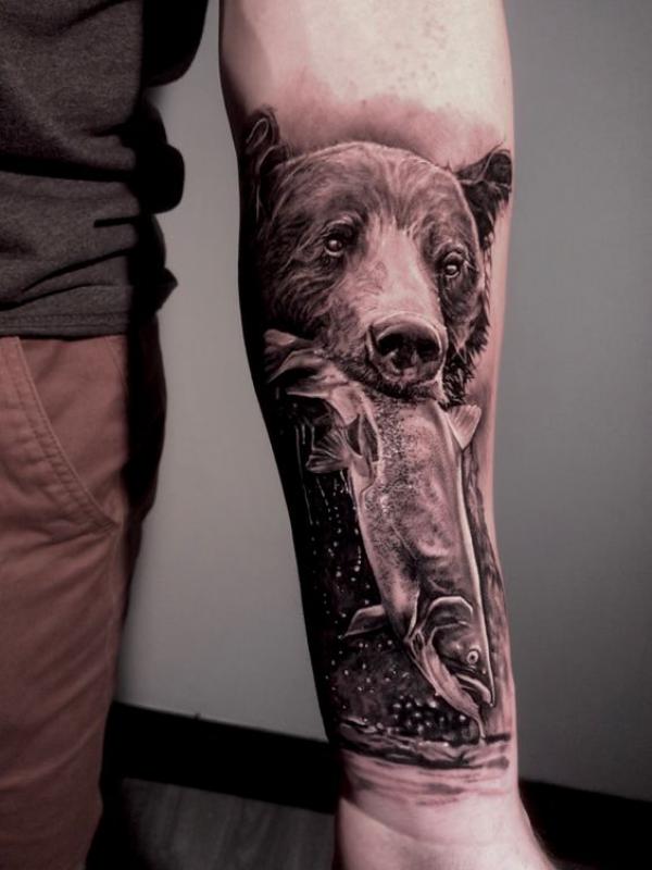 A grizzly bear holding a fish in its mouth