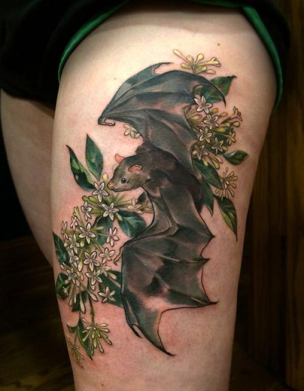 Bat and honeysuckle thigh tattoo