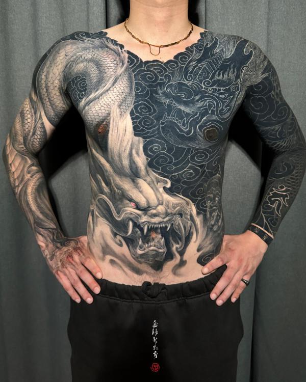 Japanese themed tattoo sleeve. A man with a 3/4 sleeve of japanese style  tattoos including a dragon, origami crane and | CanStock