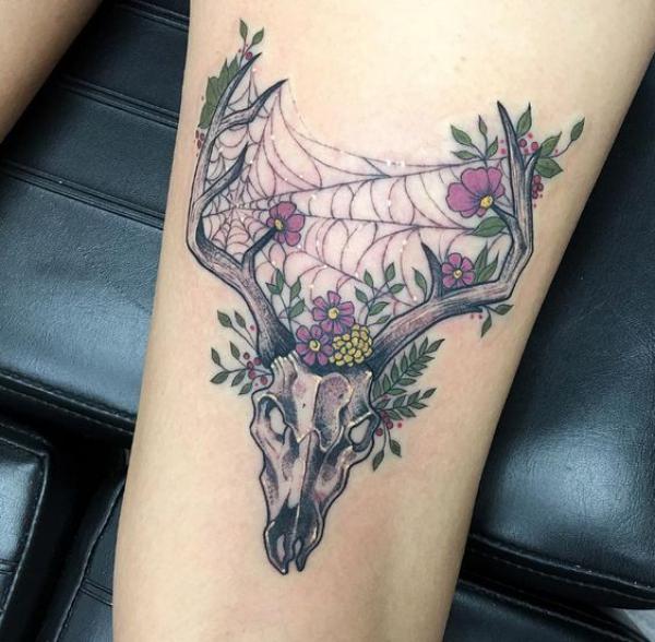 Deer skull with spider web ferns and flowers