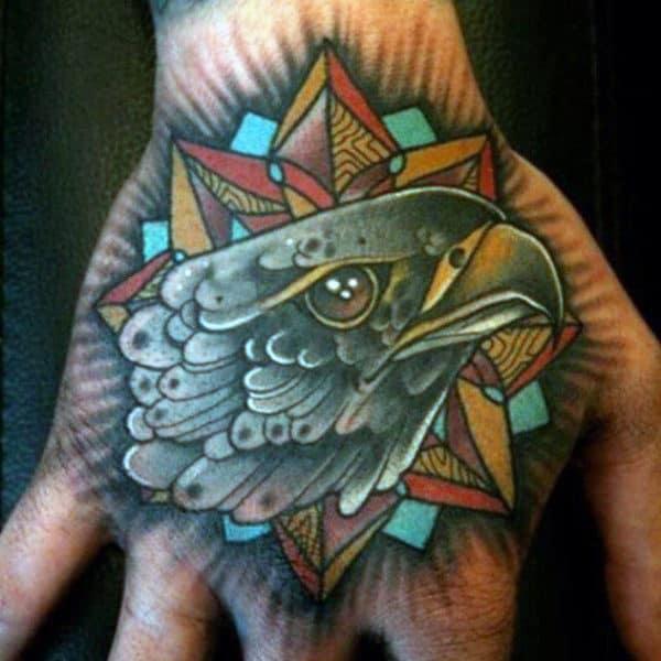 Falcon head with star and halo hand tattoo