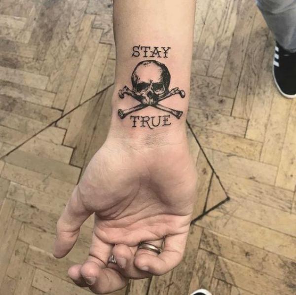 Jolly roger wrist tattoo with words Stay True